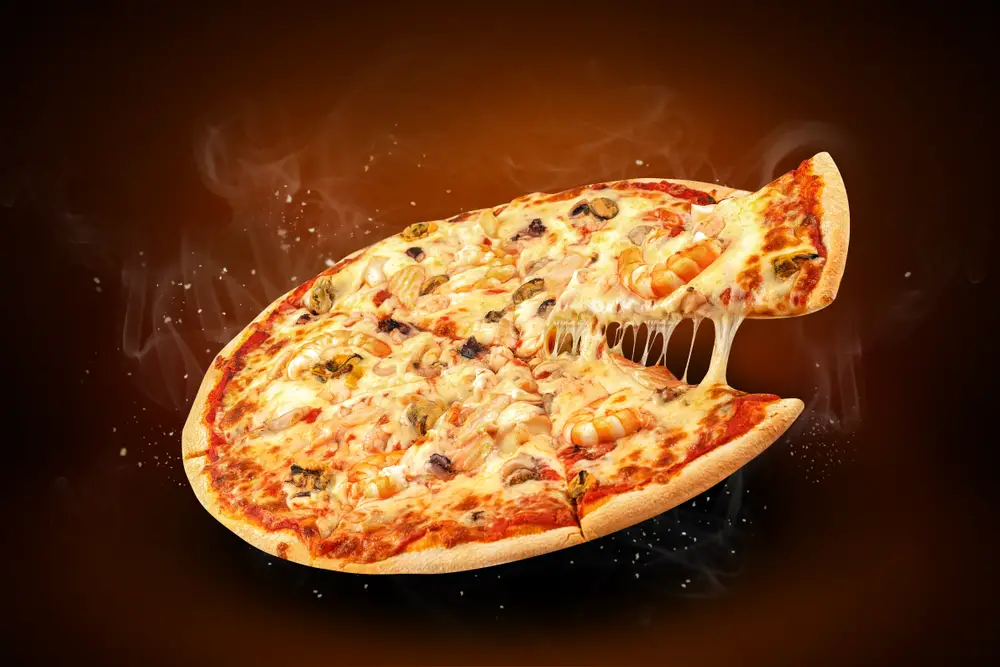 ¿Cuál es la temperatura mínima de mantenimiento en caliente para la pizza?