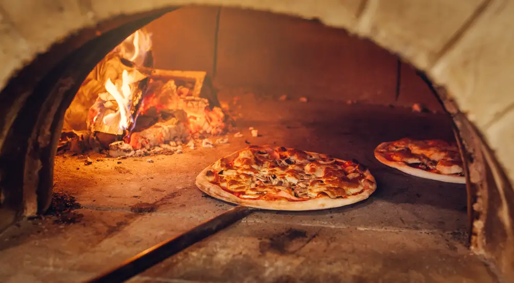 ¿Cuál es la temperatura mínima de mantenimiento en caliente para la pizza?